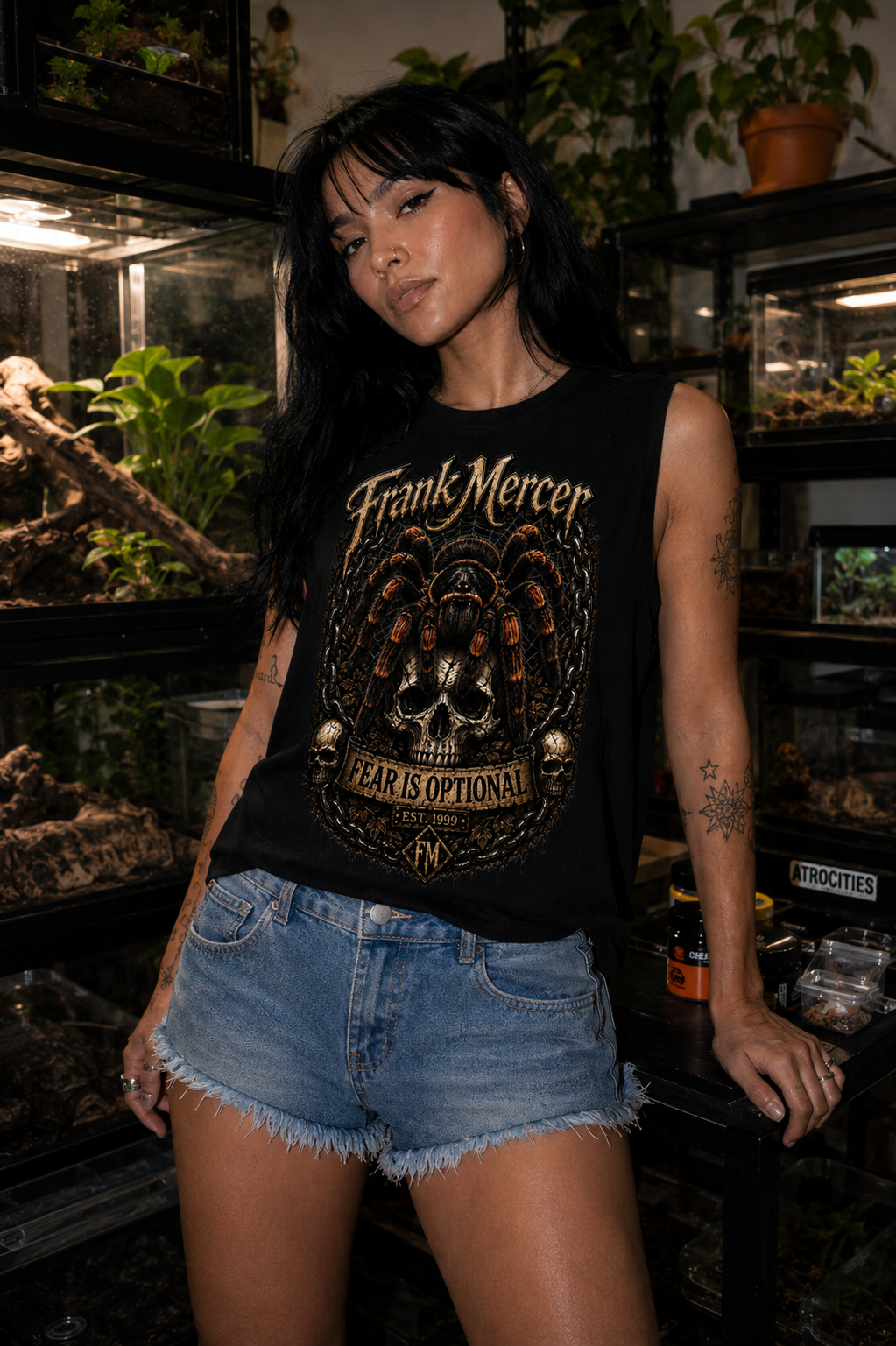 Woman wearing a black t-shirt with 'Frank Mercer' design in an indoor setting with plants and shelves.